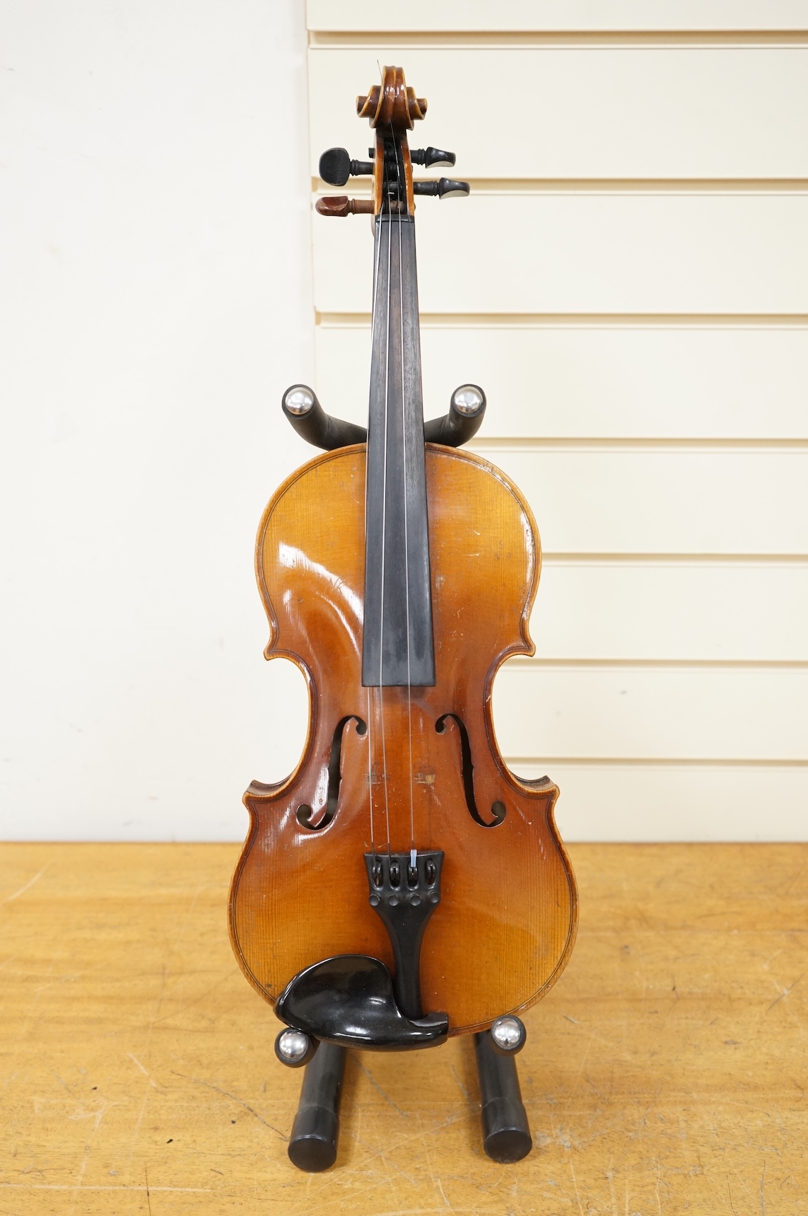 Five cased 20th century violins, including; a German violin, two Czech violins, a three-quarter size violin with a label for Bienfait, and a Romanian quarter size violin, all in cases or the remains of cases.